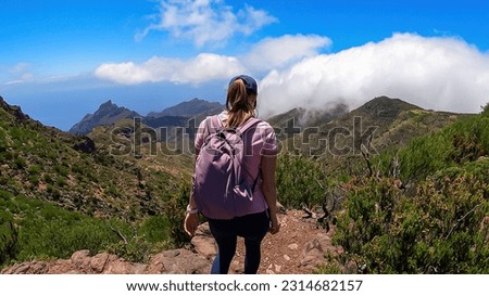 Woman with backpack enjoying panoramic view on the Teno mountain massif seen from summit Pico Verde, Tenerife, Canary Islands, Spain, Europe. Hiking trail between Masca and Santiago. Wanderlust vibe Royalty-Free Stock Photo #2314682157