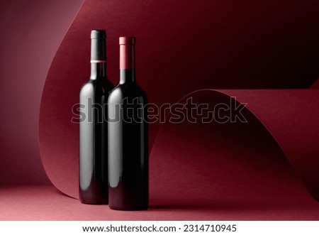 Bottles of red wine on a red background. Copy space.