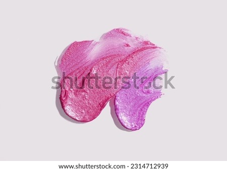 Silky shimmering  lipstick smudge texture gray background 