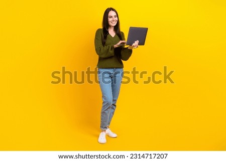 Full length photo of cheerful nice person use wireless netbook networking isolated on yellow color background