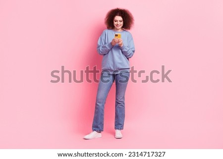 Full length photo of cheerful positive woman dressed blue sweatshirt chatting apple samsung iphone device isolated pink color background