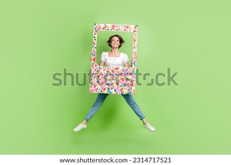 Full size portrait of pretty cheerful girl jumping hold paper album set card isolated on green color background