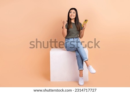 Full body photo of young blogging girl using new gadget smartphone direct finger empty space web store isolated on beige color background Royalty-Free Stock Photo #2314717727