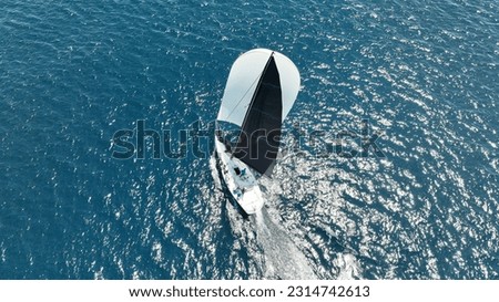 Aerial drone photo of beautiful sailing boat with white sails cruising deep blue Aegean sea, Greece