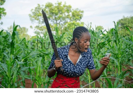 beautiful african farmer happy with the news she saw on her phone
