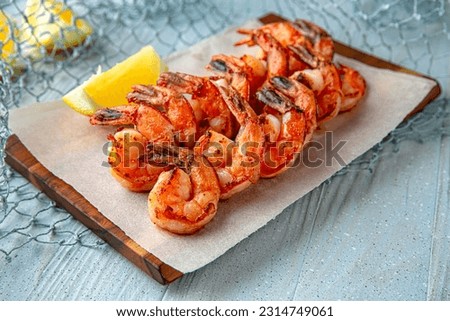 Grilled king prawns on a blue background. Mediterranean Kitchen. Sea mood menu. Royalty-Free Stock Photo #2314749061