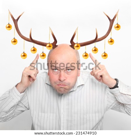 Funny picture of an man with reindeer antlers and christmas decoration.