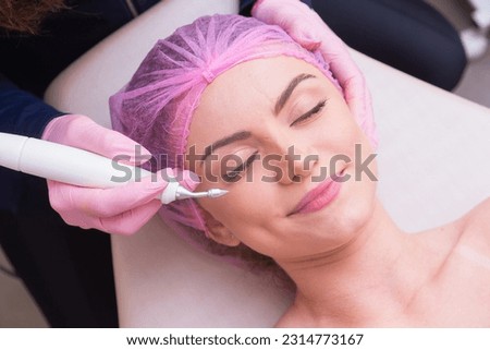 closeup photo of woman's face, photo of aesthetics, anti aging procedures. Plasma jet application. Aesthetics, spa. beautician. Royalty-Free Stock Photo #2314773167