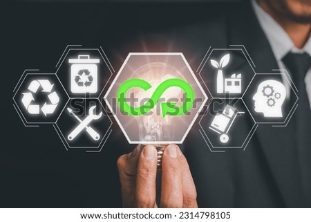 Circular economy concept, Businessman hand holding Light bulb with circular economy icon on virtual screen, renovating and recycling existing materials and products as much possible.