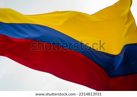Colombia flag waving in a blue cloudy sky Royalty-Free Stock Photo #2314813931