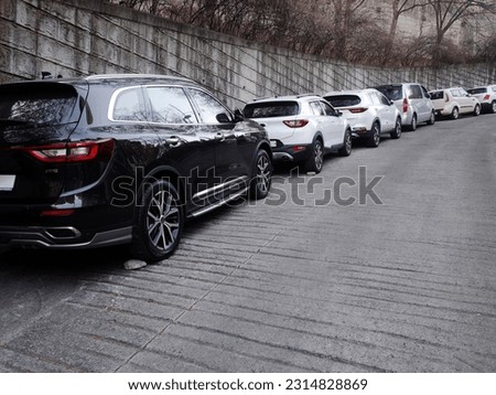 a view of cars and fences parked uphill Royalty-Free Stock Photo #2314828869