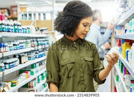 Pharmacy, health shop and woman with medicine for reading label, check product and choice in retail store. African female person looking at drugstore pills for ingredients, information and shopping Royalty-Free Stock Photo #2314839905