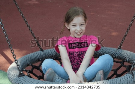 Beautiful little girl swinging on a swing. The concept of family happiness, summer vacation.
