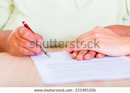 Photo of an elderly woman sign the testament Royalty-Free Stock Photo #231485206