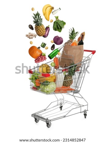Market assortment. Different products falling into shopping cart on white background Royalty-Free Stock Photo #2314852847