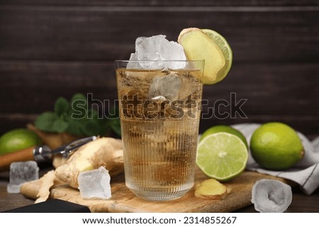 Glass of tasty ginger ale with ice cubes and ingredients on wooden table Royalty-Free Stock Photo #2314855267