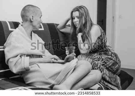 A conversation between two women on a couch. Relations between women, love, friendship. Mother and daughter. Black and white photo.
