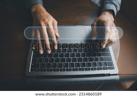 Businessman's hand typing on laptop, searching and browsing the internet for information using a blank search bar. Search engine optimization and networking concept is depicted.