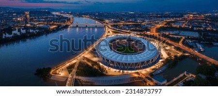 Budapest, Hungary - Aerial panoramic view of Budapest at dusk, including illuminated National Athletics Centre, Rakoczi bridge, Puskas Arena and MOL Campus skyscraper building at background at sunset Royalty-Free Stock Photo #2314873797
