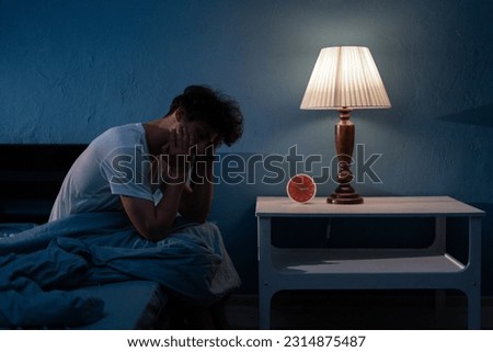 Sleepless, man suffering from insomnia, sleep apnea or stress. Tired and exhausted guy. Headache or migraine. Awake in the night. Frustrated person with problem. Copy space Royalty-Free Stock Photo #2314875487