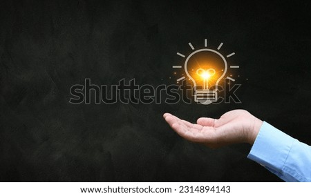 Male hand giving a light bulb icon , under the concept of sparking ideas creativity Royalty-Free Stock Photo #2314894143
