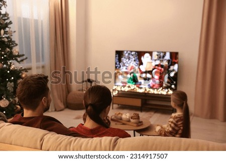 Family watching TV in cosy room. Christmas atmosphere Royalty-Free Stock Photo #2314917507