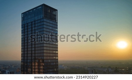 Single, tall , residential skyscraper and rising sun, aerial view.  Royalty-Free Stock Photo #2314920227