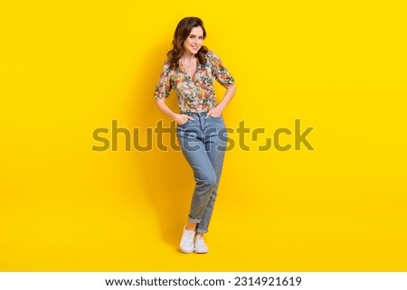 Full body photo of young beautiful lady wear flowers print shirt denim jeans preppy posing for magazine isolated on yellow color background