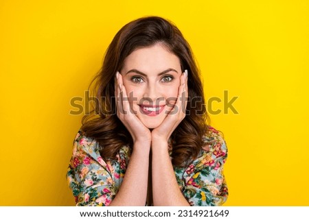 Photo of stunning positive lady arms touch cheeks beaming smile isolated on yellow color background