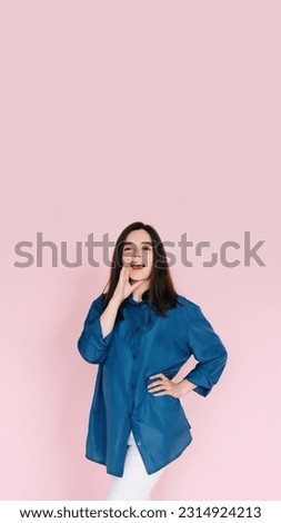 Excited Girl Sharing Breaking News: Hand Near Open Mouth Conveying Surprise and Delivering Important Information in an Empty Space, Isolated on a Pink Background. Royalty-Free Stock Photo #2314924213