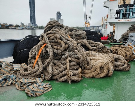 Heaps of ropes, Nets, close-up of black fishing nets. large rope anchor that has already been used. Curled up on green boat background, boat sheath, alongside in port and water transport boat concept.