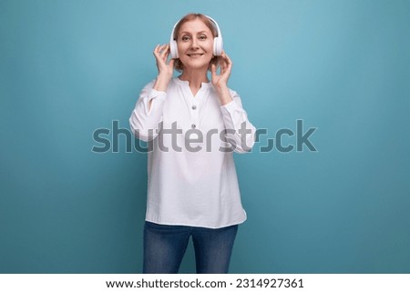 middle-aged woman with blond hair listening to music on wireless headphones