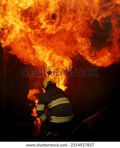 Firefighter extinguishing a fire in a burning building. Firefighters fighting a fire.