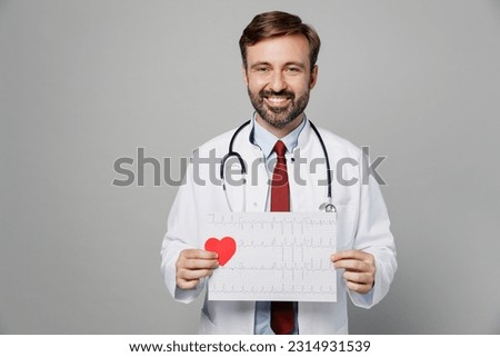 Male doctor man wearing white medical gown suit work in hospital hold electrocardiogram record heart ekg cardiogram chart of wave in paper isolated on plain grey background Healthcare medicine concept Royalty-Free Stock Photo #2314931539
