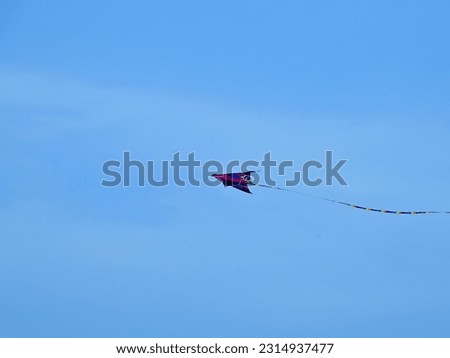 a lone isolated colourful flying kite with blue sky background