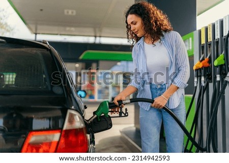 A student puts fuel in his car before leaving home for college Royalty-Free Stock Photo #2314942593
