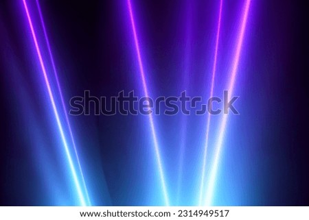 Blue and violet beams of bright laser light shining on black background Royalty-Free Stock Photo #2314949517