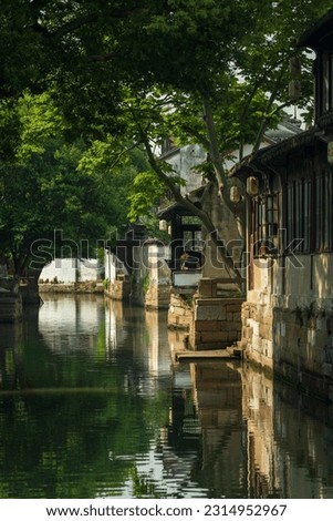 landscape of a Chinese ancient town with river, wooden houses and boat. Royalty-Free Stock Photo #2314952967