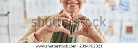 Middle aged lady designer with tape measure shows heart with han