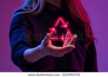 Woman holding virtual, digital, neon colored symbol of recycling. Modern technologies in global business sphere. Concept of business, modern technologies, network, digitalization