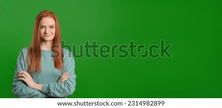 Chroma key compositing. Pretty young woman with red hair against green screen