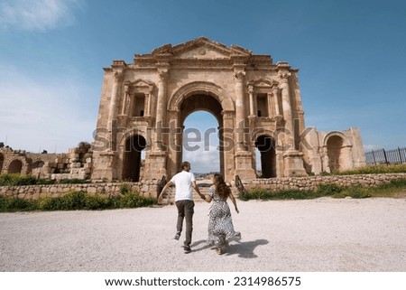 Young couple enjoying their trip while strolling in Hadrian's Arch, forum of the ancient city of Jerash, Jordan Royalty-Free Stock Photo #2314986575
