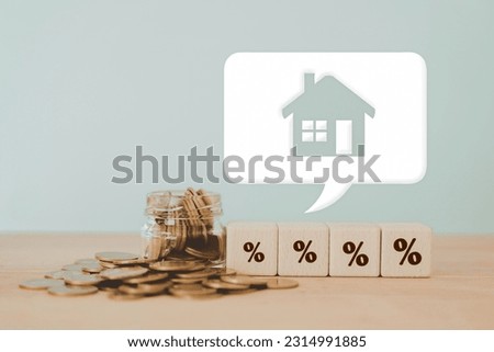 different size of percentage sign on wooden cube blocks and blurred coins in jar with house icon on white speech bubble.Concept of Interest rate financial mortgage rates, home loans, home refinance