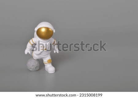 Astronaut toy in action isolated on a grey background.