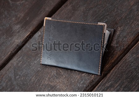 Passport with leather cover on wooden table