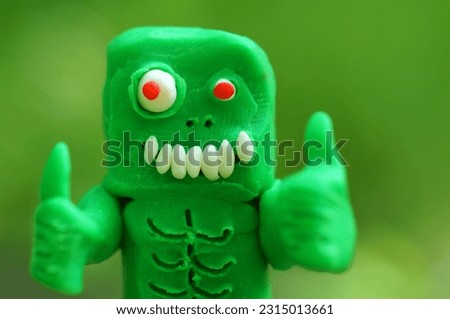 A toy zombie made of plasticine with thumbs up.