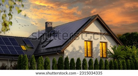 Solar panels on a gable roof. Large modern house and solar energy. Sunset. Royalty-Free Stock Photo #2315034335