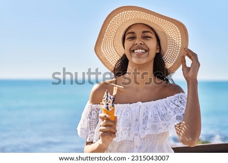 Young african american woman tourist smiling confident eating ice cream at seaside