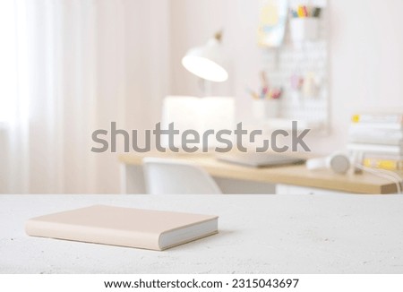 Book on table with blurred teenager room background Royalty-Free Stock Photo #2315043697