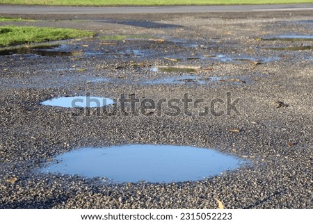 puddles in dirt road after rain Royalty-Free Stock Photo #2315052223